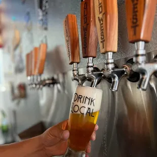 a hand holding a pint of beer