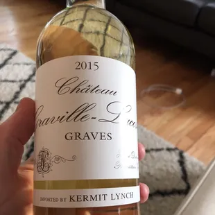a hand holding a bottle of wine