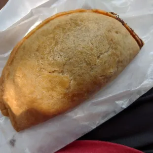 a close up of a sandwich wrapped in wax paper