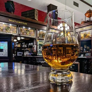 a glass of whiskey on a bar