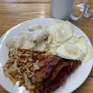 Eggs, bacon, hash browns and biscuit and gravy for an inexpensive breakfast.