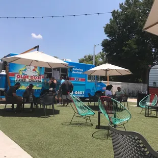 a group of people sitting at tables under umbrellas