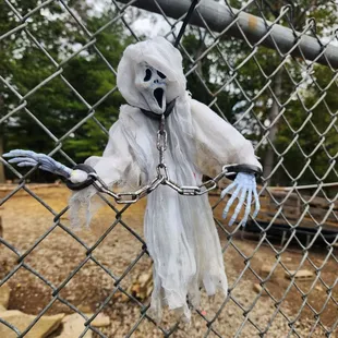 a ghost hanging on a chain link fence