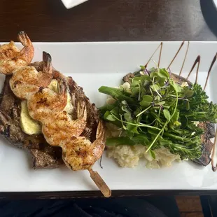 Wagyu steak with skewered seasoned shrimp, Parmesan risotto, and broccolini.