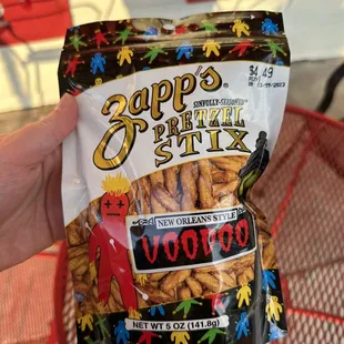 a hand holding a bag of chips