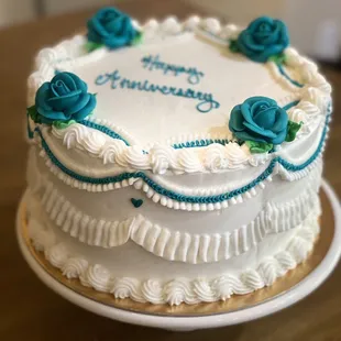 a white cake with blue roses