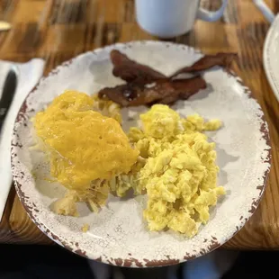 a plate of eggs, bacon, and hash browns