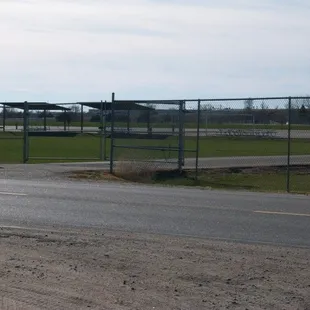 a fenced area with a stop sign in the foreground