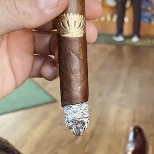 a hand holding a cigar