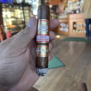 a hand holding a cigar