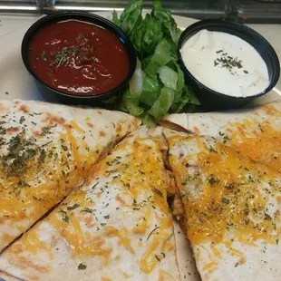 a quesadilla with a side of dips