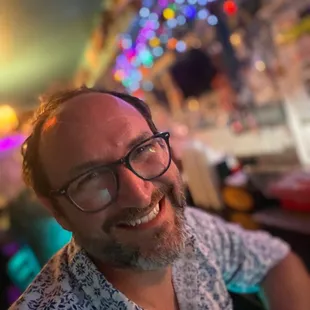 a man with glasses smiling