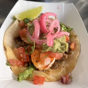 Surf &amp; Turf Taco! Grilled steak &amp; shrimp, pico de gallo, guacamole &amp; pickled onions. On a warm corn tortilla.