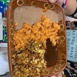 Chorizo with eggs , rice and beans . and a side of mole sauce