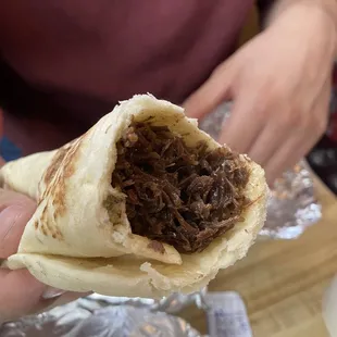 a person holding a burrito