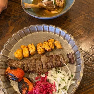 Lamb shank, saffron chicken skewer, steak skewer