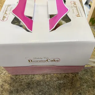 Carry out cake box with handles on top and they include a plastic cake cutter on the side of the box.