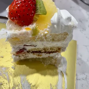 The inside of the cake is layered with fresh strawberry pieces and whipped cream.