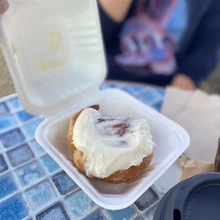 a person taking a bite out of a doughnut