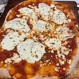 a homemade pizza on a wooden cutting board