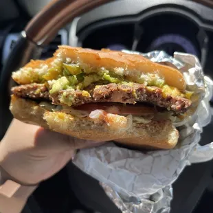 Cheeseburger with jalapeño and avocado - half eaten to show the evenness of ingredients
