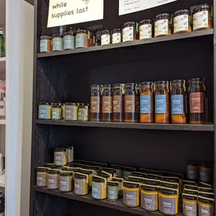 a shelf full of jars of honey