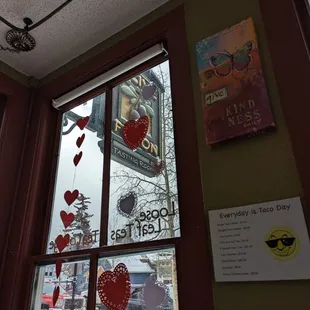 a view of a window with hearts hanging from it