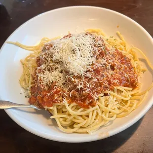 a bowl of spaghetti with sauce and parmesan cheese