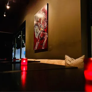 a table with candles and a painting on the wall