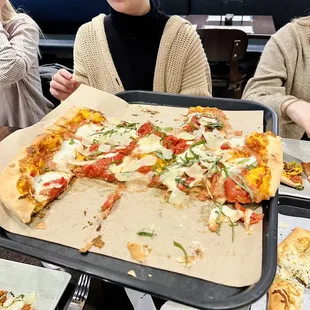 a woman holding a pizza