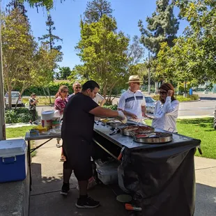 Guillermo cooking up some chicken, beef and pork tacos and quesadillas .