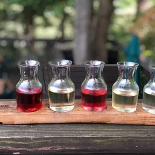four glasses of wine on a wooden tray