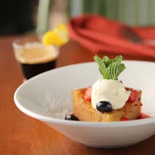 a plate of french toast with whipped cream and berries