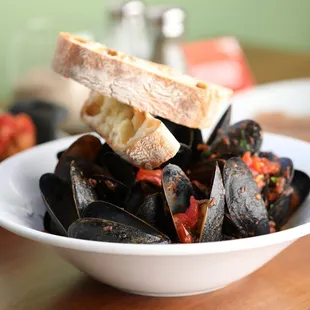 a bowl of mussels and bread