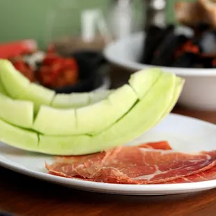 a plate of meat and melon