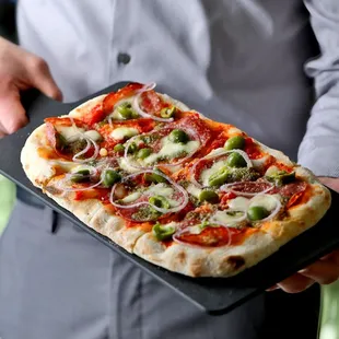 a man holding a pizza