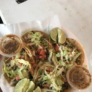a plate of tacos with lettuce and salsa