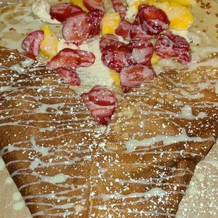 Dessert crepe with: mango, strawberries, cream cheese frosting, &amp; drizzled with Lachera!