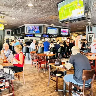 people sitting at tables and watching televisions