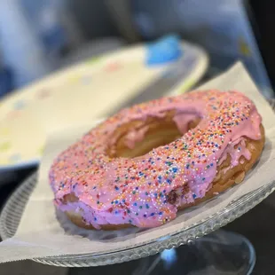 a pink frosted donut with sprinkles