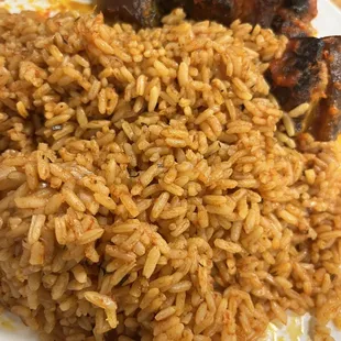 Jollof rice with stewed rice, one piece of meat missing, we were too excited to take a picture and ate first