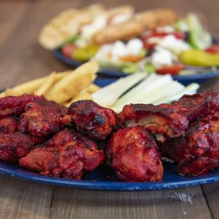 a plate of chicken wings and french fries