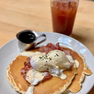 a plate of pancakes with eggs and bacon