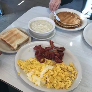 a breakfast of eggs, bacon, toast, and pancakes