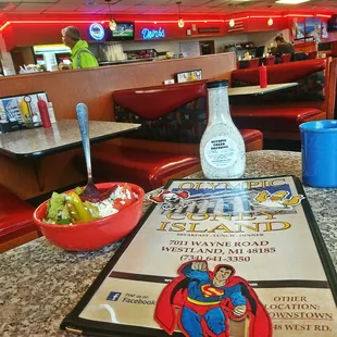 a menu and a bowl of fruit