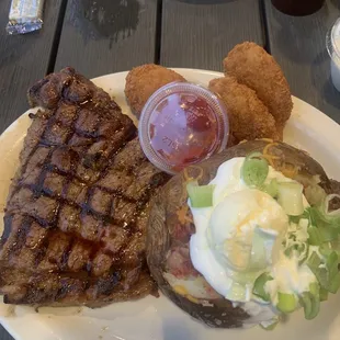Steak and fried shrimp with loaded baked potato