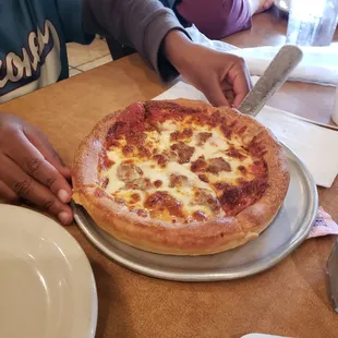 a person cutting a pizza