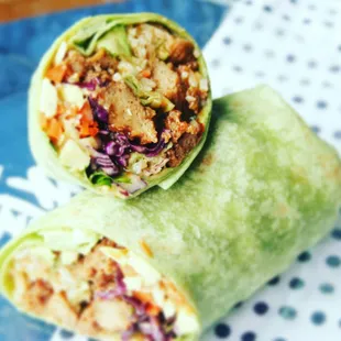 Spicy Korean BBQ Burritos with seitan, cabbage, miso tahini cream, jasmine rice, cilantro, jalapeños, carrots, and avocado.