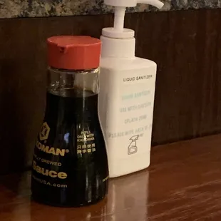 The set up on table of soy sauce and hand sanitizer.