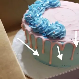 a pink and blue cake in a box